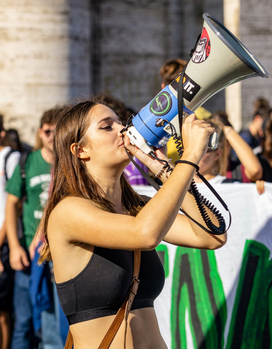 Woman holding a megaphone up to her face at a protest